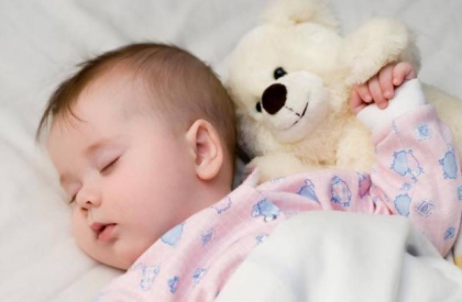новорожденный сладко спит с игрушечным медвежонком