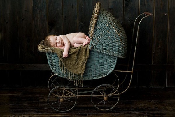 младенец дремлет в плетенной коляске